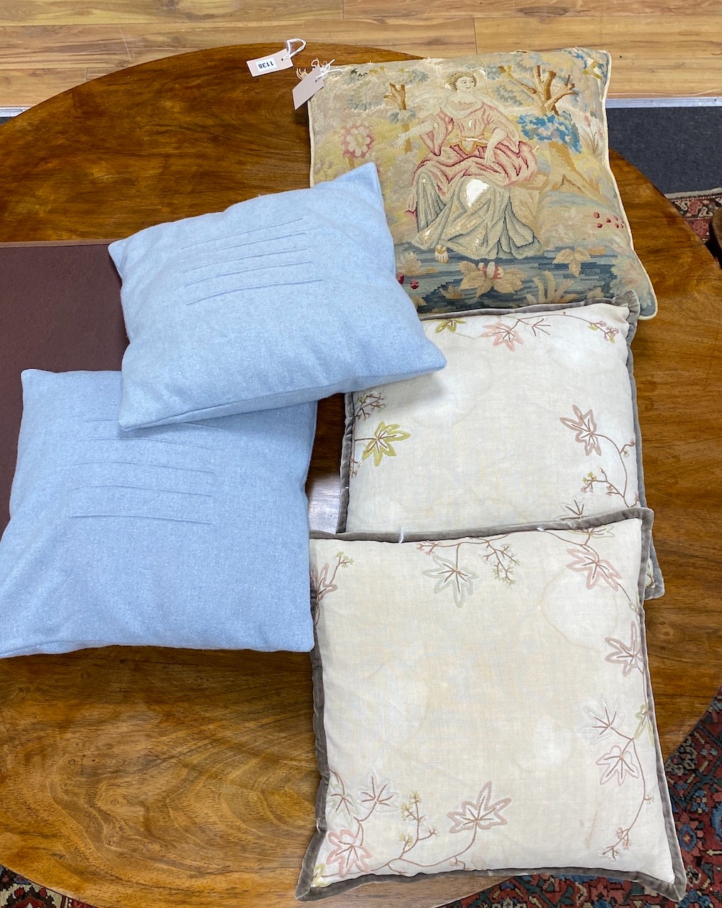 A 19th century petit point polychrome tapestry now as a cushion, 48cm x 46cm together with four later cushions.